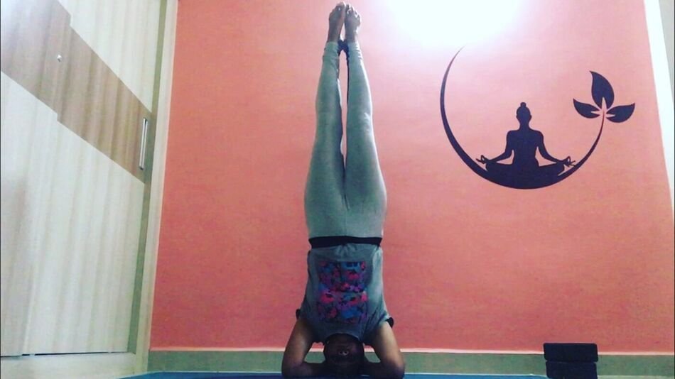 Nitya in Sirsasana, a supported headstand
